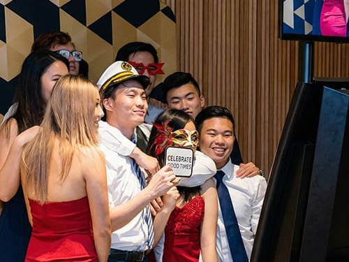 People Using Photo Booth at School Ball